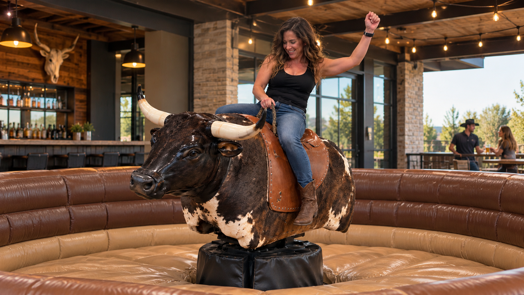 Commercial mechanical bull operating inside an entertainment venue with protective landing mattress
